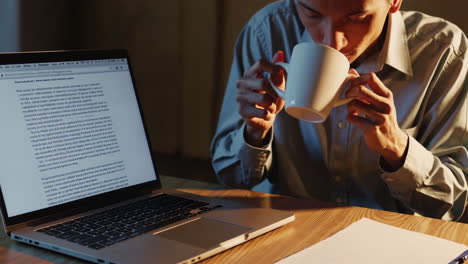 man working late at night on laptop and taking notes.