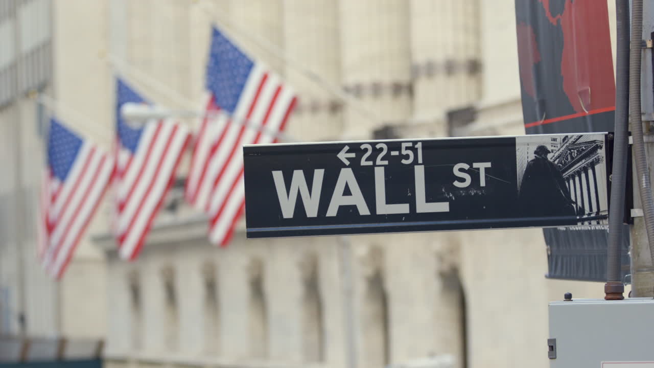 Wall St Street Sign in the Financial District of New York with three American Flags in the Background