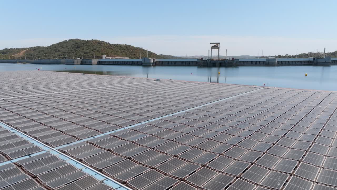 volando hacia la pared de la presa sobre una enorme granja de energía solar flotante