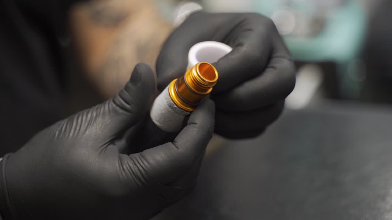 Tattoo machine prepare to work with band before use, shot in slowmotion 120fps