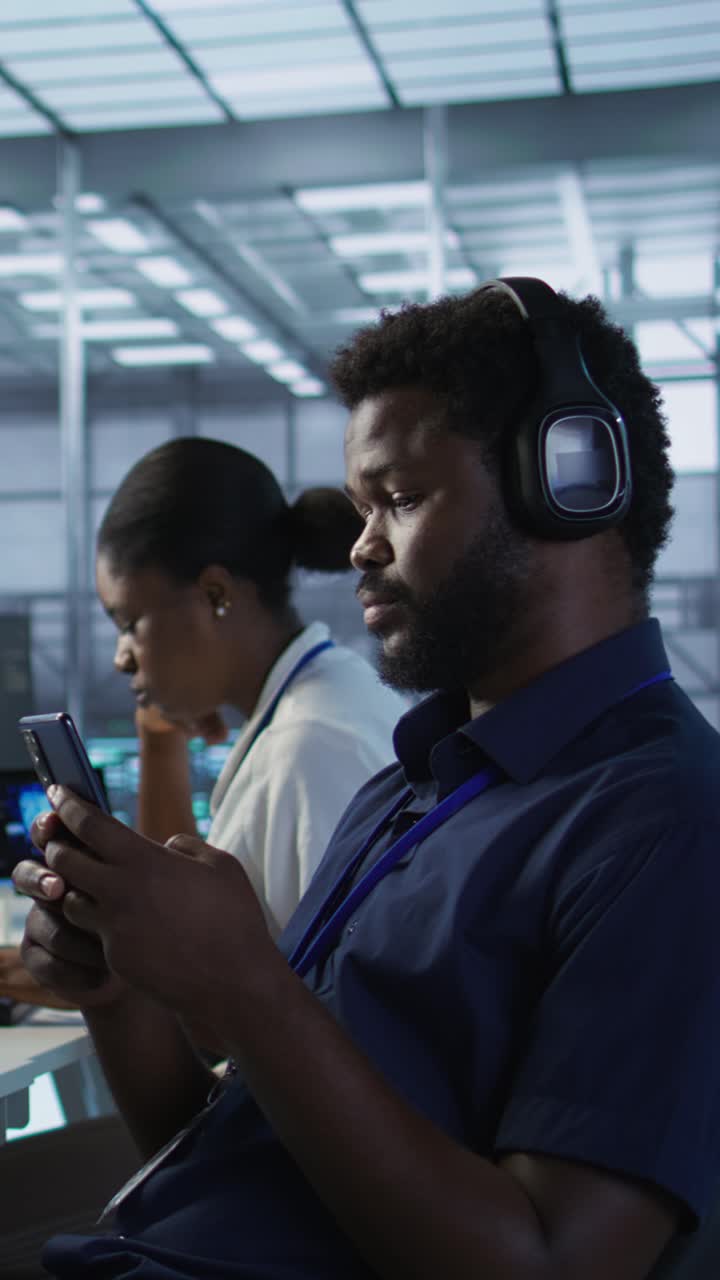 Vertical video Data center IT expert texting on smartphone, taking break