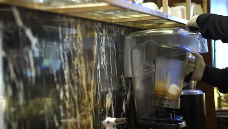 shot of chef using grinder machine filling with iced pieces inside a restaurant