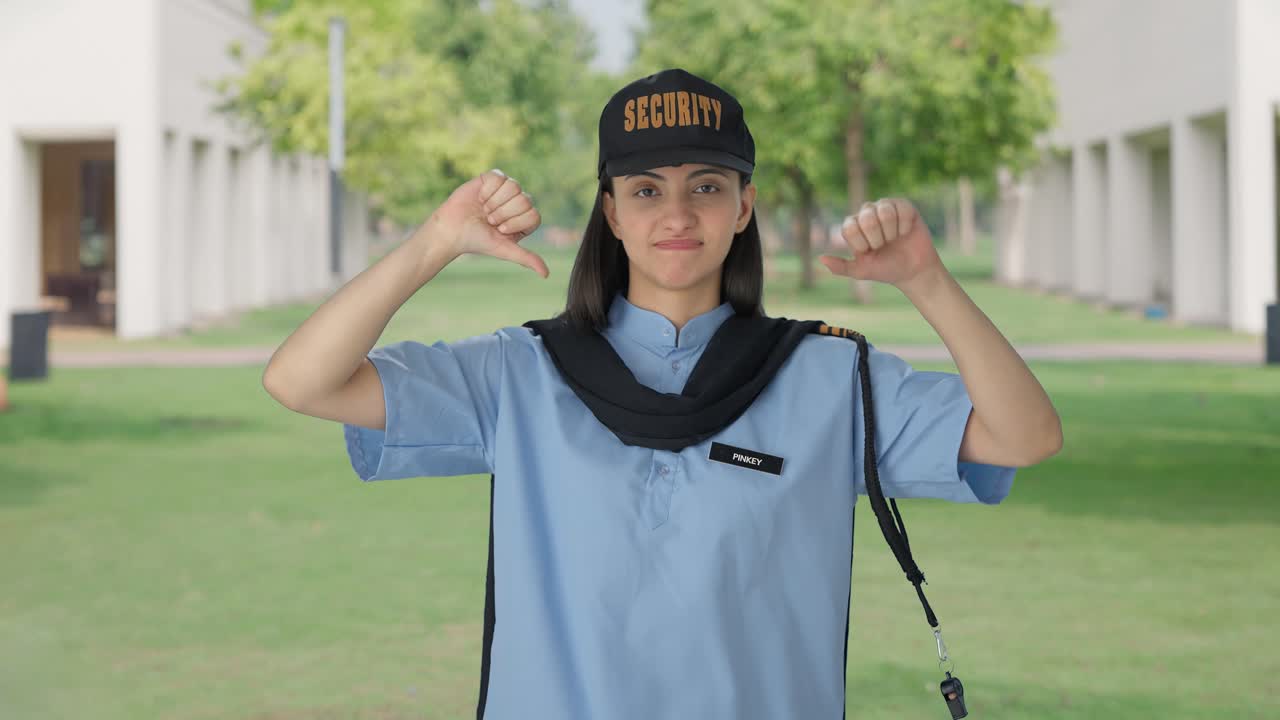 Upset Indian female security guard showing thumbs down