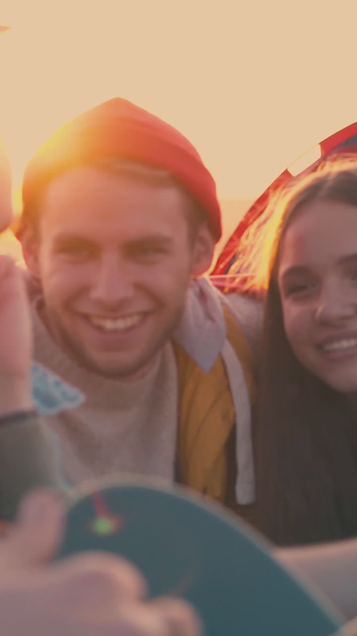 beautiful girl sings song to guitar resting with friends in camp after day hike in warm autumn evening closeup