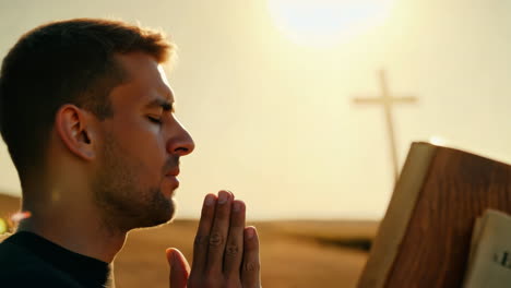 man praying at outdoor religious altar during golden hour