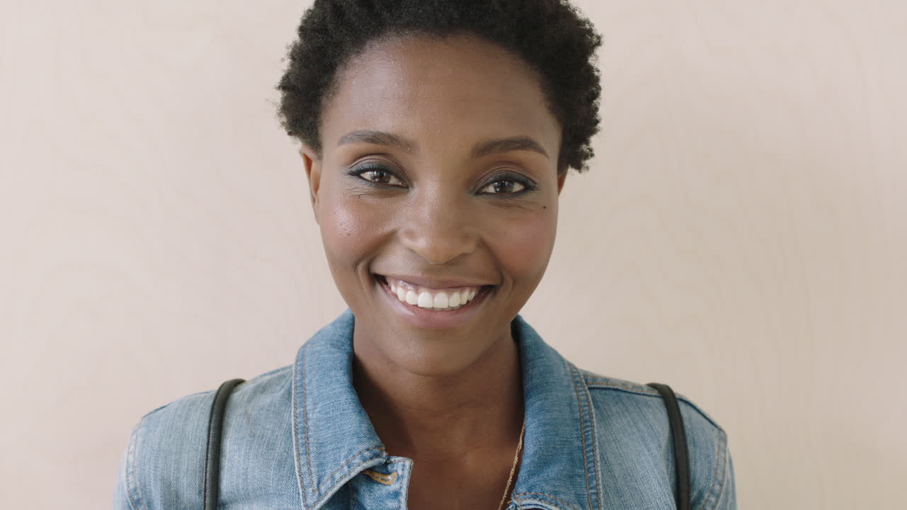 retrato en primer plano de una mujer afroamericana de moda riendo alegremente a la cámara