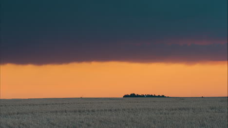 sunset over farmed fields with peaceful clouds moving past