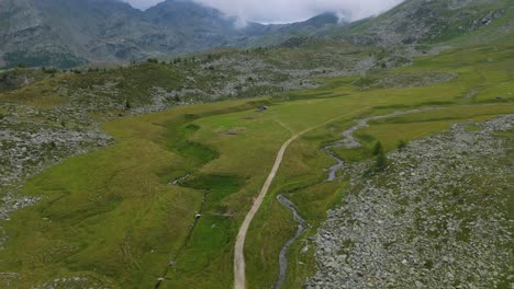 Aerial-Flying-Over-Path-On-Mountain-Hillside-Top-Over-Rocks-In-Valmalenco