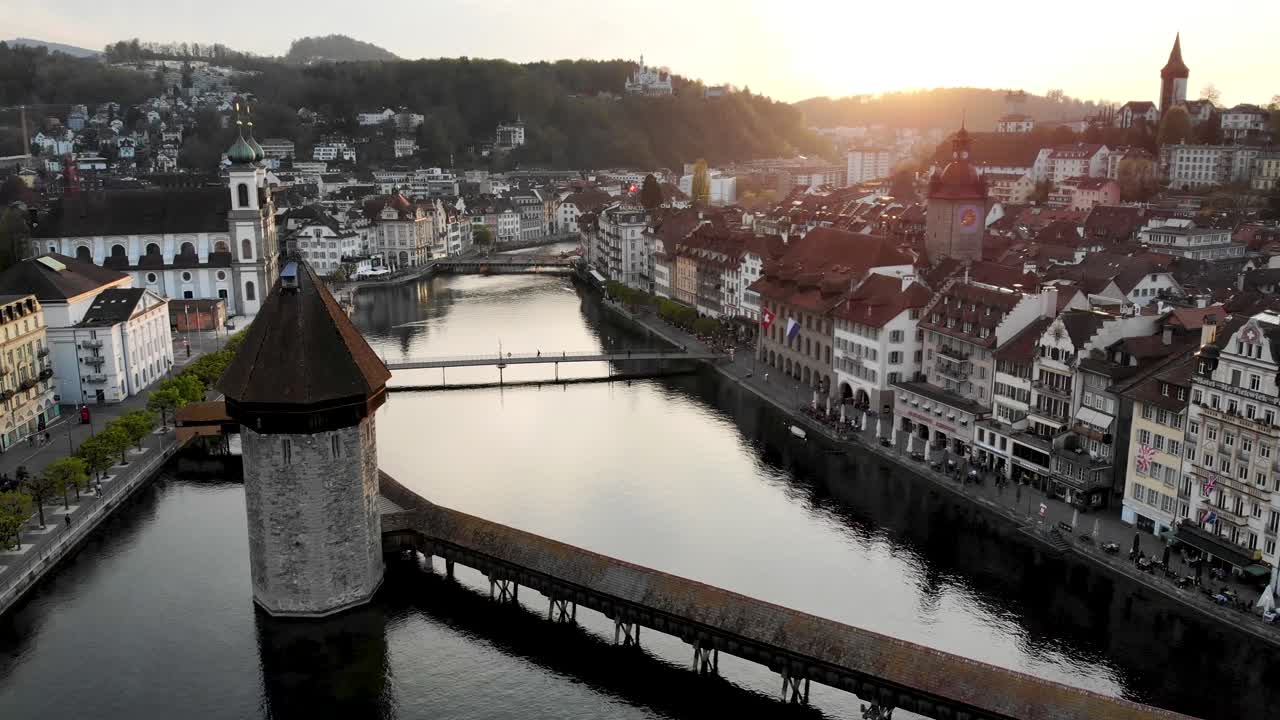 vista aérea de lucerna, suiza mientras se mueve desde el puente kappelbrücke hacia la puesta de sol detrás del histórico altstadt