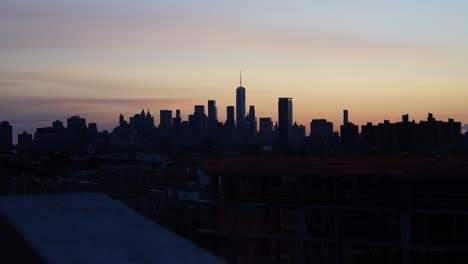 new york city skyline with world trade center viewed from brooklyn office building at beautiful sunset