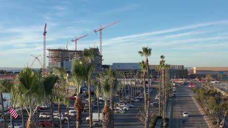 the new convention center being build in chula vista california, drone rising from behind palm trees