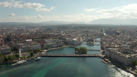 Aerial-shot-following-the-Rhone-river-through-central-Geneva-on-a-sunny-day