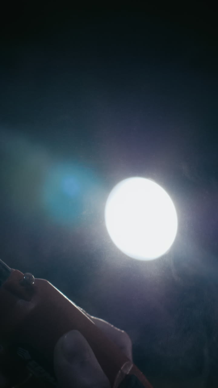 Close-up of a person using a drill in a dark room