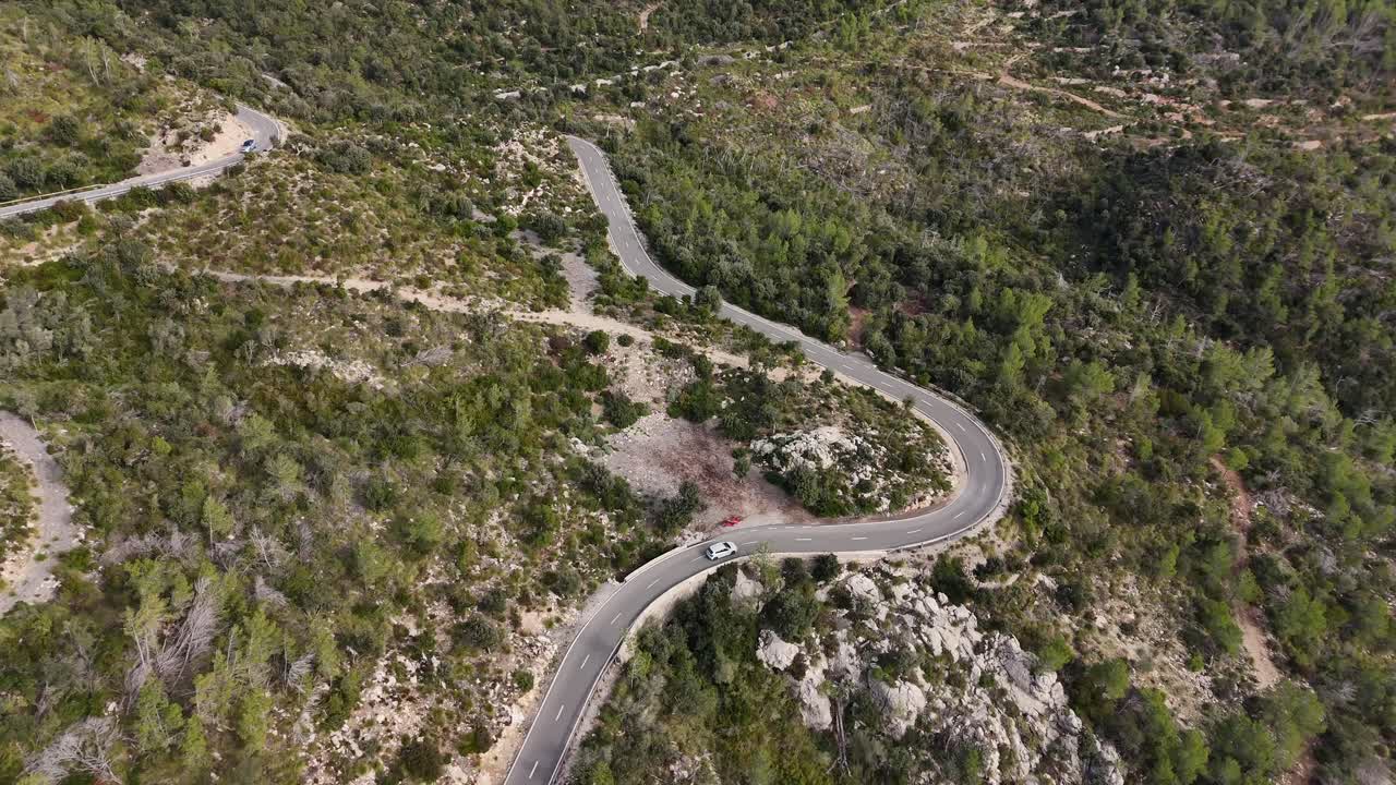 tomada de un avión no tripulado de un coche que conduce en la carretera en el valle de sporles en la aldea de la isla de mallorca en la serra de tramuntana, españa