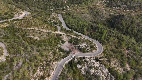 drone shot of driving car on the road in the esporles valley on the island village of mallorca in the serra de tramuntana, spain