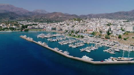 Drone-shot-over-the-marina,-seaside-boulevard,-beaches,-summer-in-Agios-Nikolaos-Crete-Greece