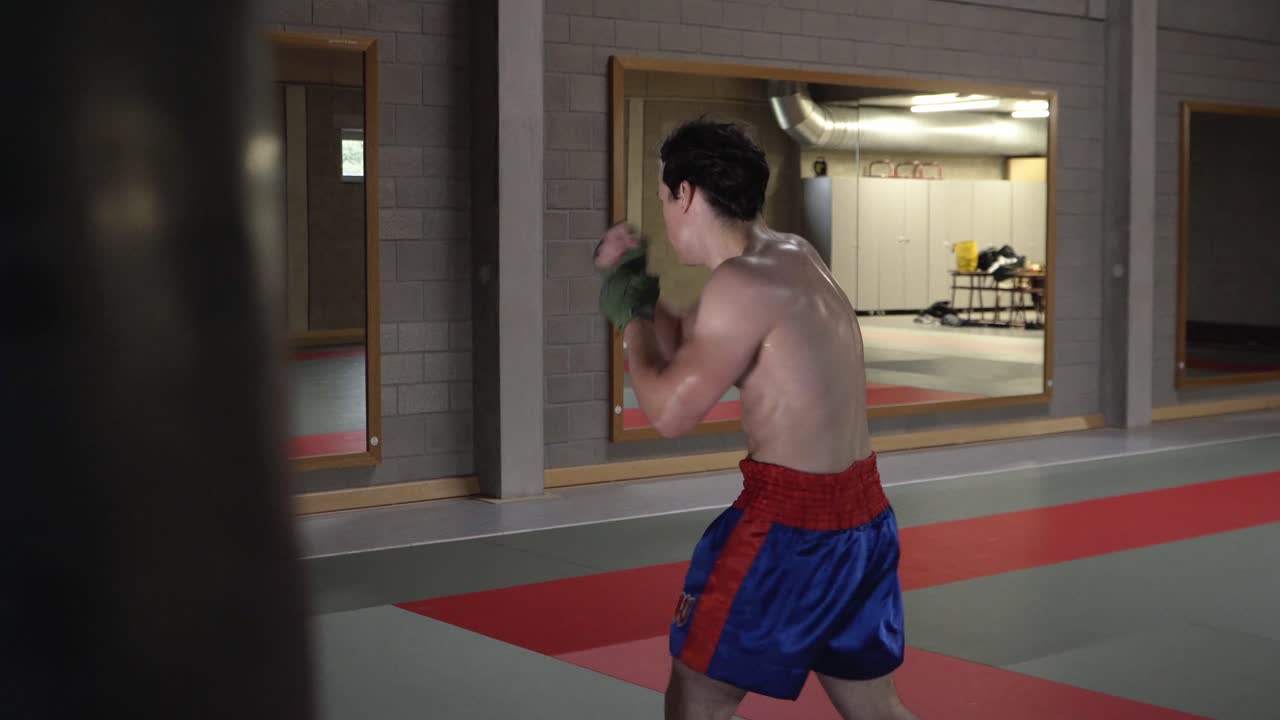 빈 체육관에서 섀도 복싱 운동을 하는 젊은 파이터