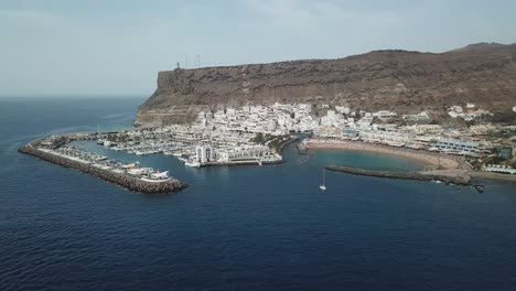 captured from a drone, the beautiful puerto de mogán coastline stretches along the blue waters of the atlantic.