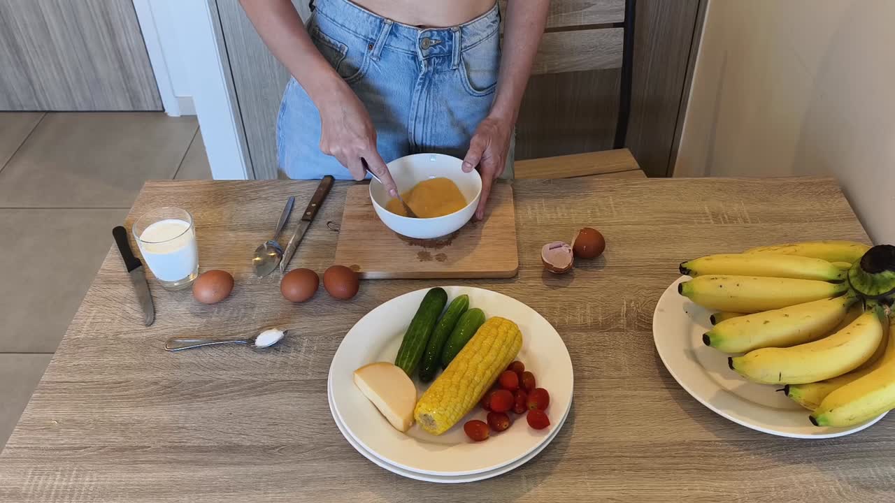Preparing a meal with eggs, vegetables, and bananas