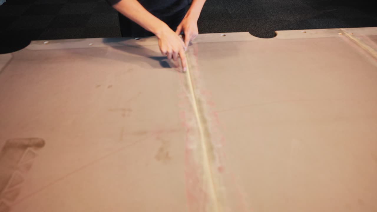Warm indoor light highlights restoration of billiard slate with putty smoothing