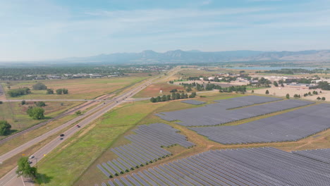aerial mountain view of large solar farm with many rows of solar panels creating green, renewable energy to replace fossil fuels and to power clean transition to fight climate change