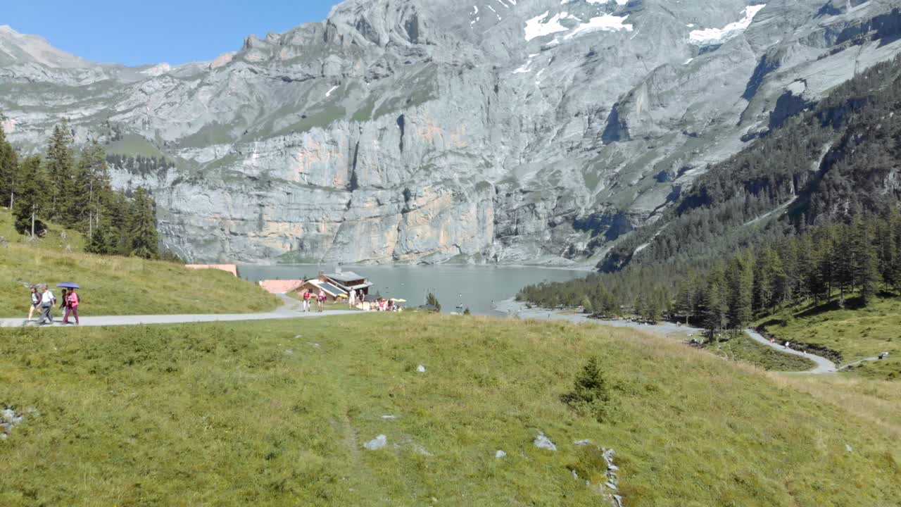 realmente hermosa y asombrosa vista arial revela disparar pasando sobre la cabeza del lago turquesa oeschinen con acantilados rocosos en el valle bajo las montañas alpinas de oberland, suiza