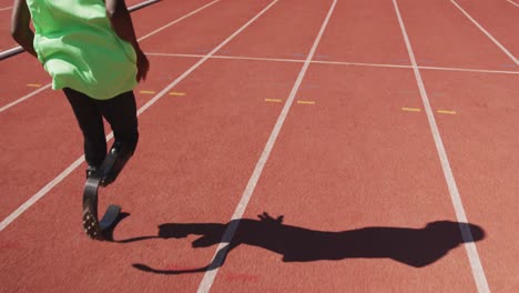 disabled mixed race man with prosthetic legs running on race track