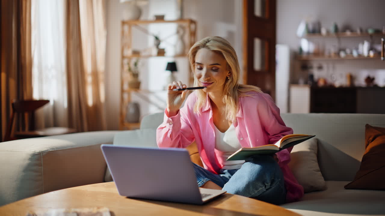 Thoughtful student online lesson writing notebook at home couch. Woman pondering