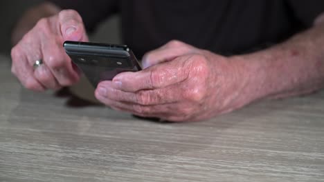 el anciano utiliza su teléfono para transacciones bancarias en línea