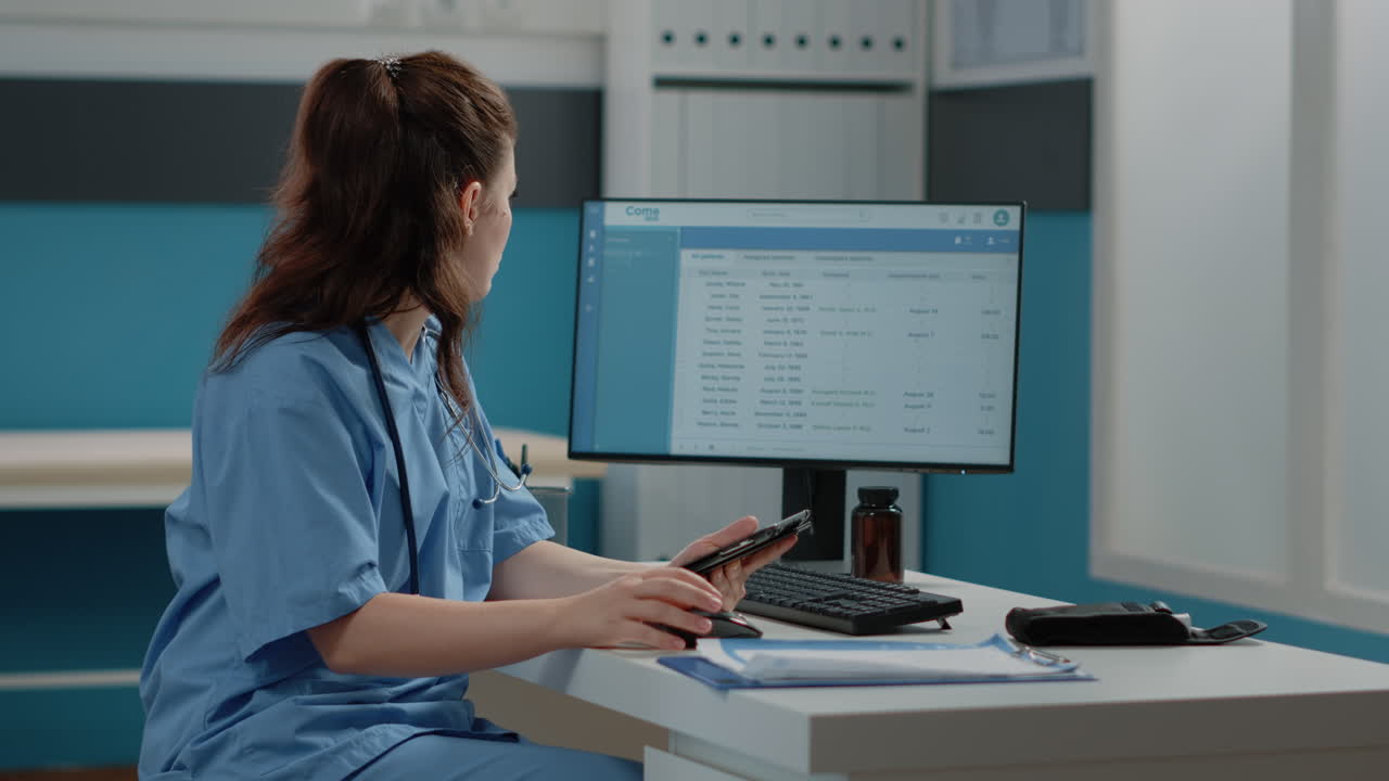 Medical professional working with patient records on tablet and computer