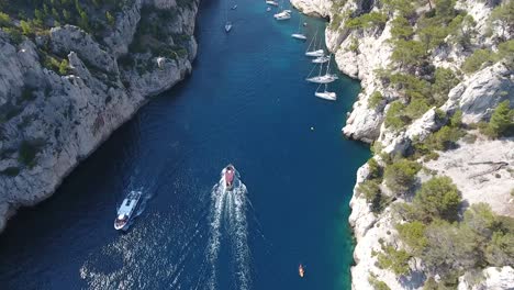 Following-a-boat-by-drone-entering-a-creek-(calanque-d'en-vau)-in-France