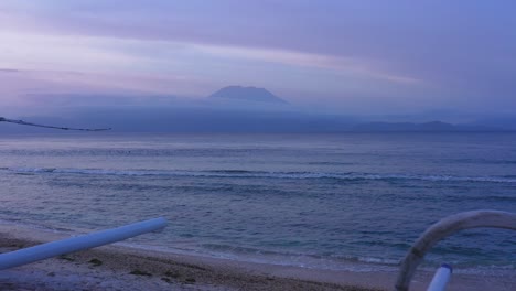 agung volcano, ocean and beach hut in indonesia, aerial pull-out