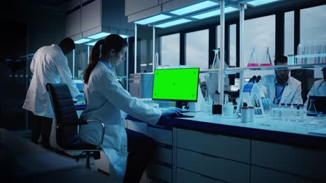 modern medical research laboratory: portrait of female scientist working on computer showing green chroma key screen. advanced scientific lab, medicine development facility biotechnology