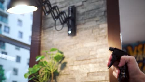 hand spraying mist in a barbershop with light and interior details in the background