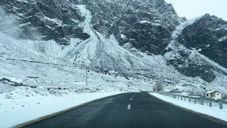 Coche-Conduciendo-Por-Una-Carretera-En-Skardu-En-Un-Paisaje-Cubierto-De-Nieve-Y-Altas-Montañas