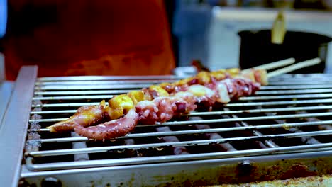 squid skewers being grilled at a street market