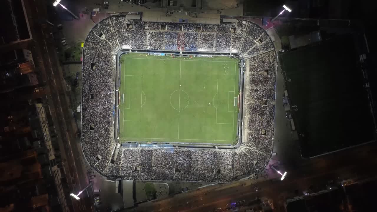 An electrifying aerial shot of a soccer stadium at night, packed with fans. Ideal for sports marketing, blogs, and event promotions.