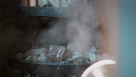 heat and steam in sauna ,pouring water on stones, smoke, close up