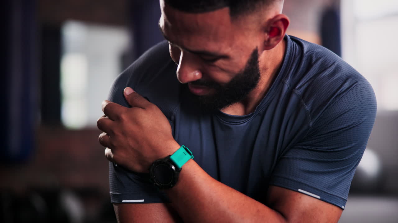 hombre con una lesión en el hombro en el gimnasio