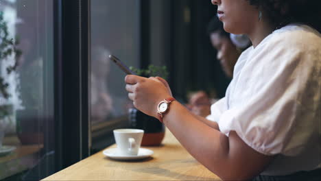 cafetería, teléfono y primer plano de una mujer escribiendo un texto