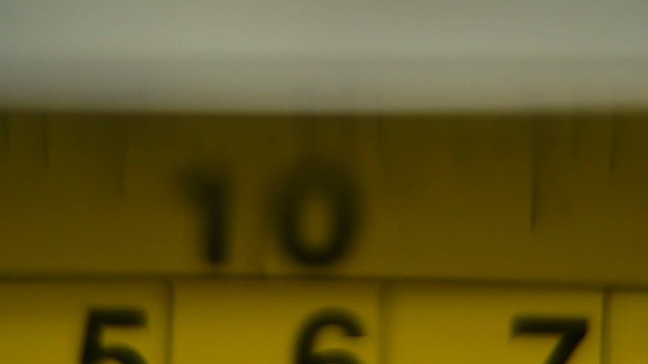 video macro de un medidor amarillo, herramienta de medición, súper primer plano, cámara lenta 120 fps, full hd, zoom out movimiento de la grúa