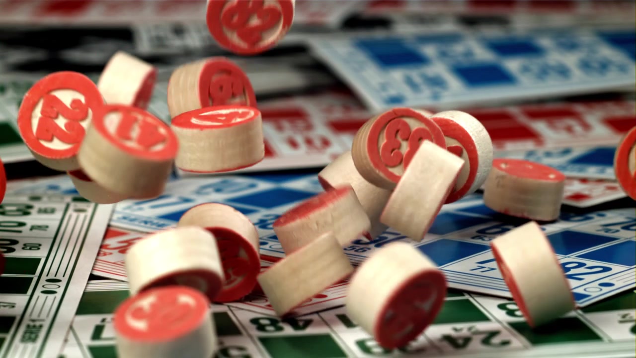 Primo piano al rallentatore di gettoni da bingo che cadono su cartelle da gioco