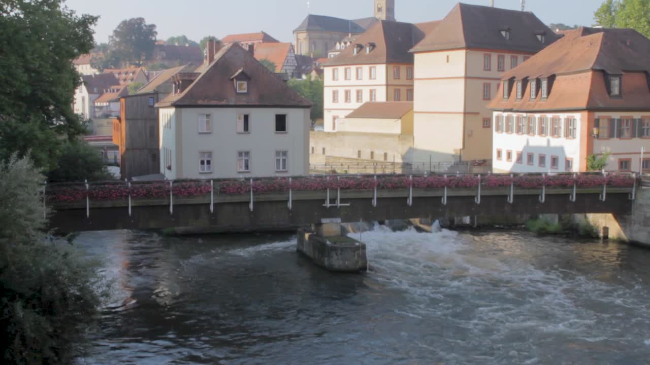 Morgenlicht beleuchtet die Würzburger Stadtansicht mit einem Fluss im Vordergrund, Aufwärtsschwenk.