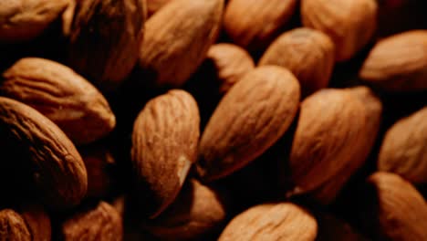 close-up-throwing-almonds-on-an-already-big-pile-of-almonds-covering-the-whole-screen