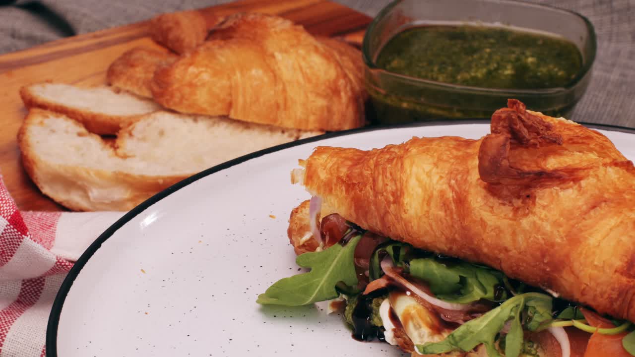 Croissant with jamon ham, Salmon, in Modern Cafe, Top View of Healthy Breakfast in Cafe. English breakfast: fried egg, bacon toast on sandwich.