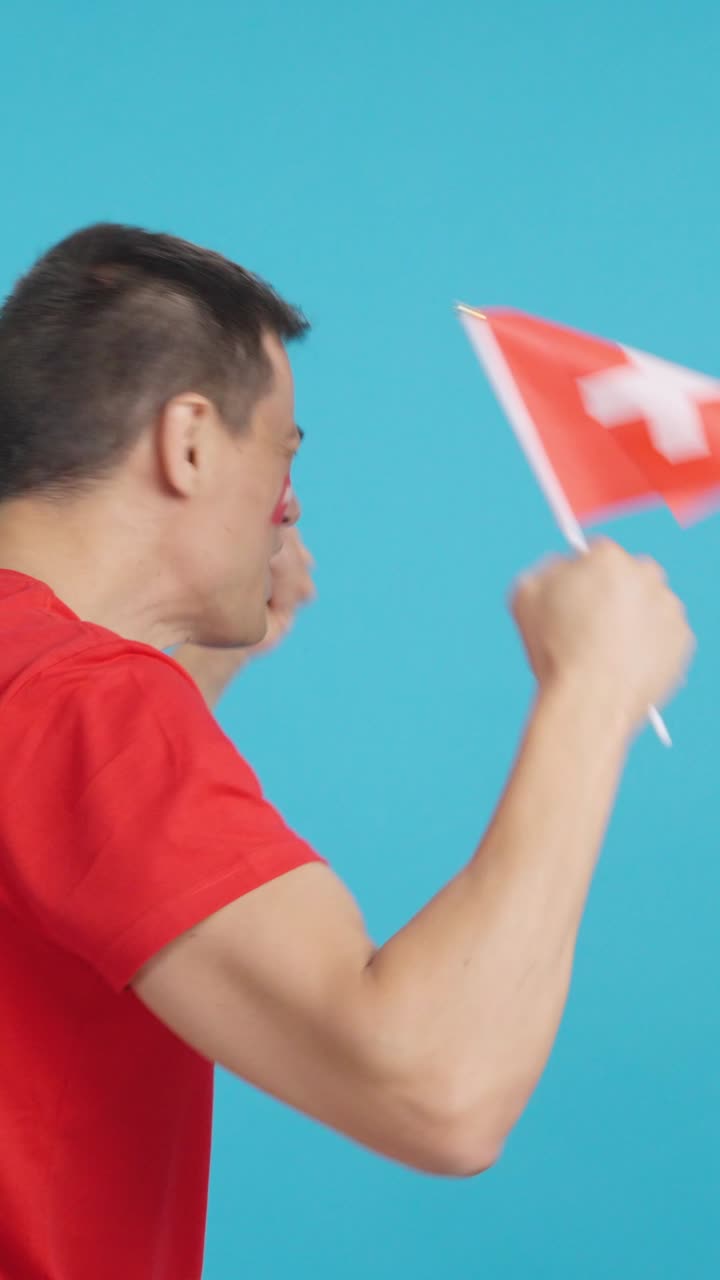 Rear view of a man waving a swiss pennant
