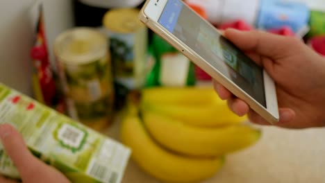 un hombre escanea el código qr en un cheque de una caja de jugo de un supermercado.