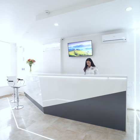 stomatology center indoors. elegant female at the reception table. beautiful woman is waiting for doctor's call. girl is sitting on luxury sofa in the waiting room.