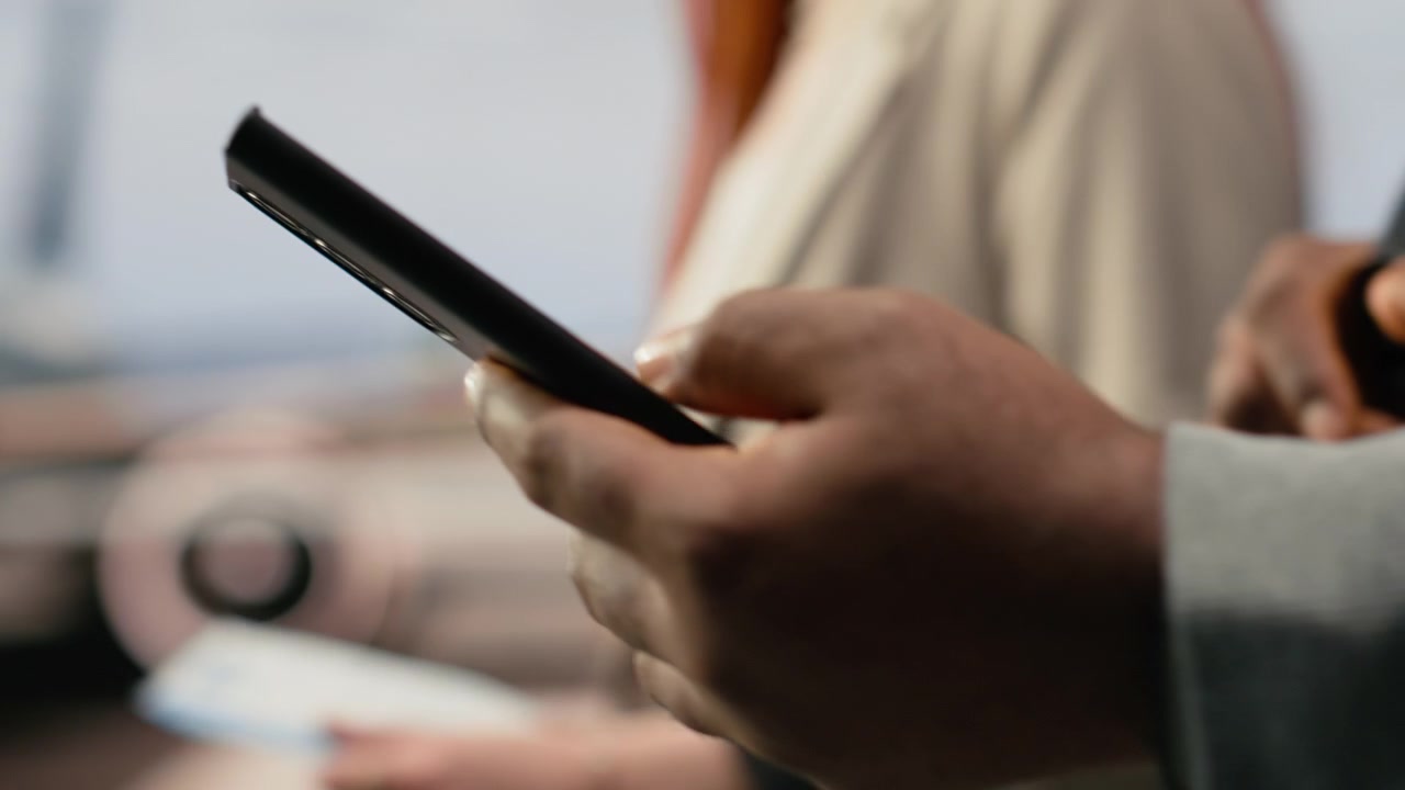 Primo piano di un uomo e una donna in aeroporto che usano laptop e smartphone