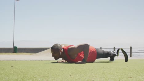 vista lateral hombre con pierna protésica haciendo flexiones